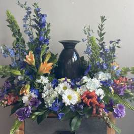 Colorful floral arrangement with a dark vase centerpiece and mixed blooms
