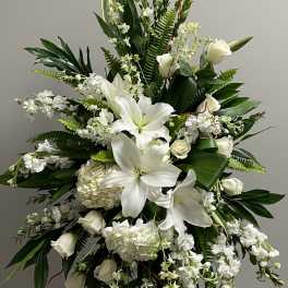 Tall white floral spray with lilies and roses on a stand