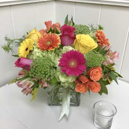 Colorful bouquet of roses, gerbera daisies, and hydrangeas in a glass vase