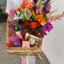 Mixed bouquet in a wooden gift basket with chocolates and soap