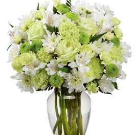Green and white bouquet in a clear glass vase
