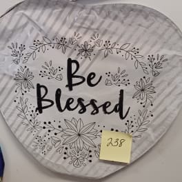Heart-shaped silver balloon with 'Be Blessed' text and black floral outlines.