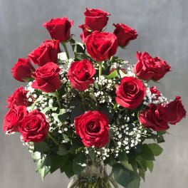 Bouquet of red roses with baby's breath in a glass vase
