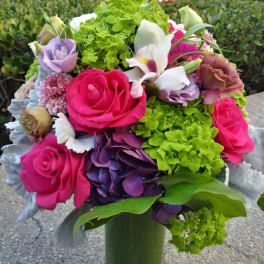 Bouquet of pink roses, hydrangeas, and white orchids in a vase