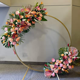 Two floral sprays arranged on a large gold circular frame