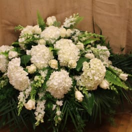 Large white floral arrangement with hydrangeas and roses