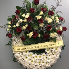 Standing funeral wreath of red and white roses with white daisies
