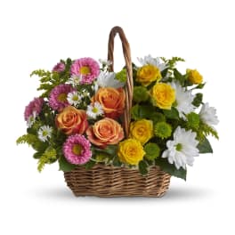 Basket arrangement of pink and yellow roses with white daisies