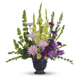 Purple and green floral arrangement in a dark vase