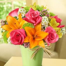 Bouquet of pink roses and orange lilies in a green vase
