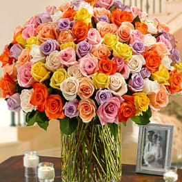 Large bouquet of multicolored roses in a clear glass vase