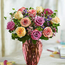 Bouquet of pink, cream, and purple roses in a metallic vase