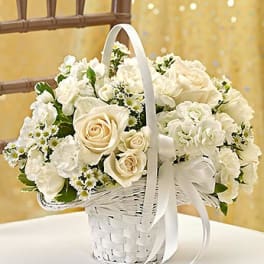 White rose bouquet in a white wicker basket with ribbon