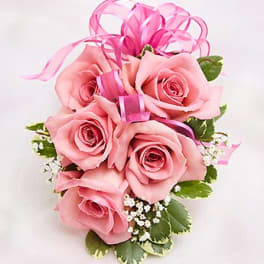 Pink rose bouquet with ribbon loops and small white filler flowers