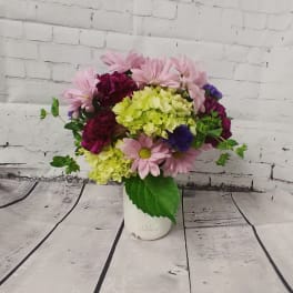 Pink daisies and hydrangeas in a white vase