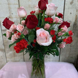 Bouquet of red and pink roses with carnations in a glass vase