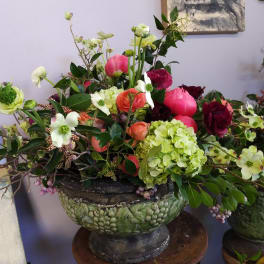 Large mixed floral arrangement in a green pedestal bowl