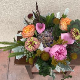 Mixed bouquet with pink peonies, orange roses, calla lilies, and zinnias