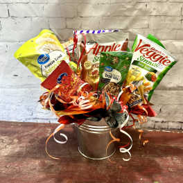 Assorted snack bags arranged in a metal bucket with curled ribbons