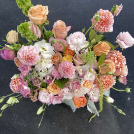 Mixed bouquet of peach, pink, and white flowers with tall green spikes