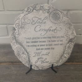 Round memorial plaque on a stand with the words "Take Comfort"