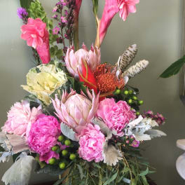Tall floral arrangement with pink and cream blooms in a vase