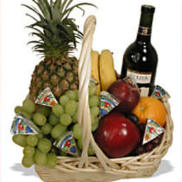 Fruit basket with pineapple, grapes, bananas, apples, and a wine bottle