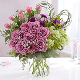 Pink roses and mixed flowers in a clear glass vase