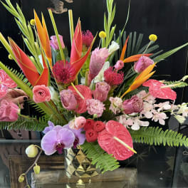 Tropical bouquet with orchids, anthuriums, and bird-of-paradise in a gold vase