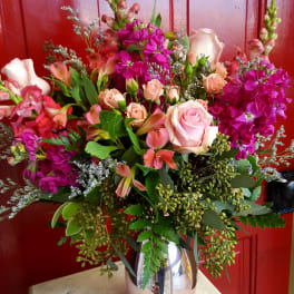Mixed pink and peach flower arrangement in a metallic vase
