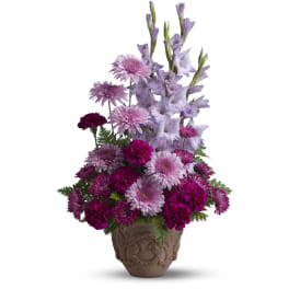 Purple and pink flowers arranged in a decorative urn vase