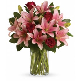 Pink lilies and red roses in a clear glass vase