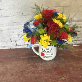Bouquet of red roses, yellow daisies, and carnations in a mug