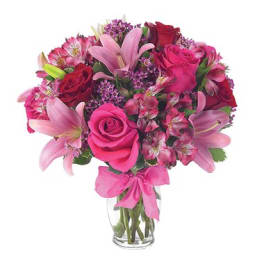 Pink and red mixed flower bouquet in a clear glass vase