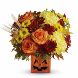 Autumn bouquet in a jack-o'-lantern vase with roses and mums