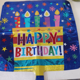 Square foil birthday balloon with colorful candles and Happy Birthday text on blue background