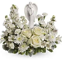White floral arrangement with an angel figurine centerpiece