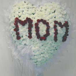 Heart-shaped white floral arrangement with red rose letters and lace ribbon