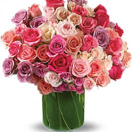 Bouquet of pink and lavender roses in a clear glass vase