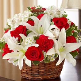 Basket of red roses and white lilies with small white filler flowers