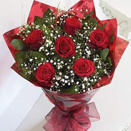 Bouquet of red roses with baby's breath wrapped in red paper