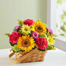 Basket of sunflowers, pink carnations, and yellow daisies