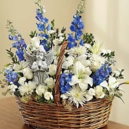 Basket arrangement of white and blue flowers with a small angel figurine