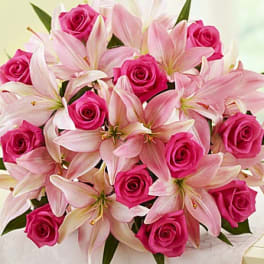 Pink roses and pale lilies arranged in a bouquet
