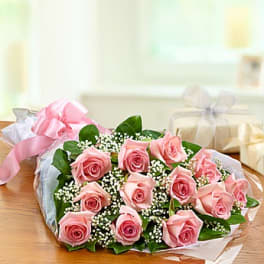 Bouquet of pink roses with baby's breath wrapped in paper