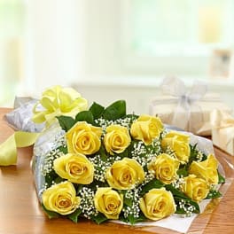 Bouquet of yellow roses with baby's breath wrapped in paper