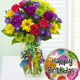 Colorful bouquet in a glass vase with a Happy Birthday balloon