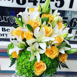 Bouquet of yellow roses and white lilies with green hydrangeas
