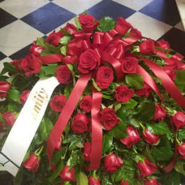 Large red rose wreath with satin ribbons on a checkered floor
