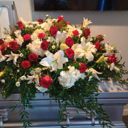 Large red and white floral casket spray with lilies and roses